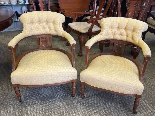 A pair of Edwardian cream upholstered tub chairs