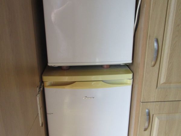 two fridge freezers, one small, one large.