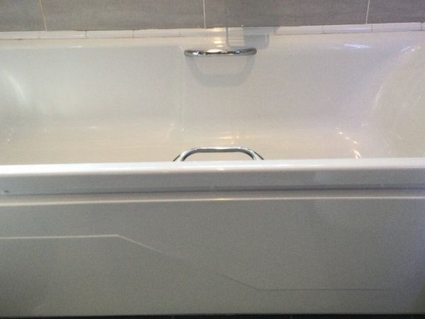Bath and side panel together with mixer taps.