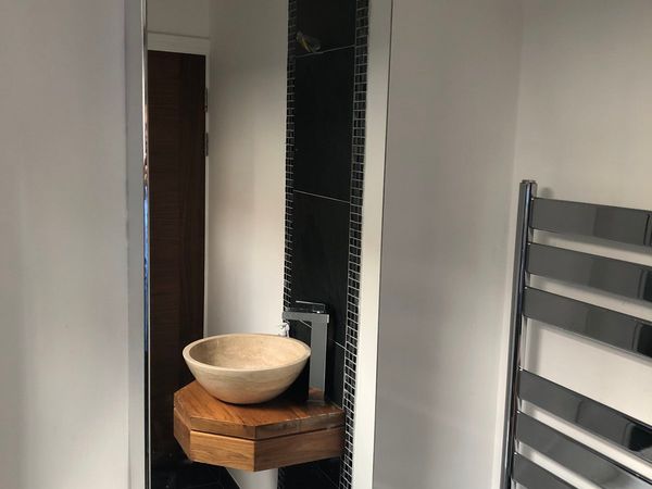 Walnut bathroom counter with stone basin and tap