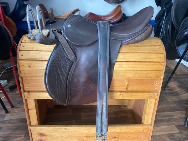 Brown leather saddle with girth and  stirrups