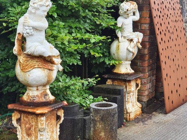 Set of four cast iron cherub statues