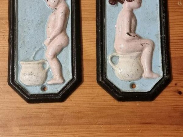 Old cast-iron he/she bathroom sign