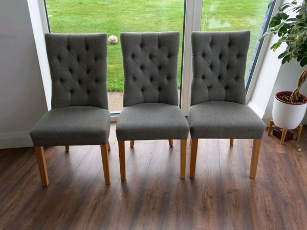 Grey material button back dining chairs