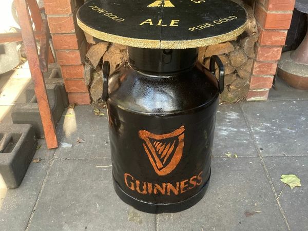 A Guinness Steel Can with a wooden table top