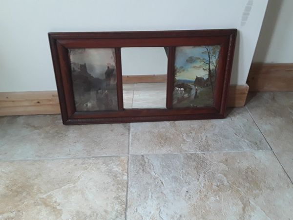 Very old antique mirror with a picture on either side