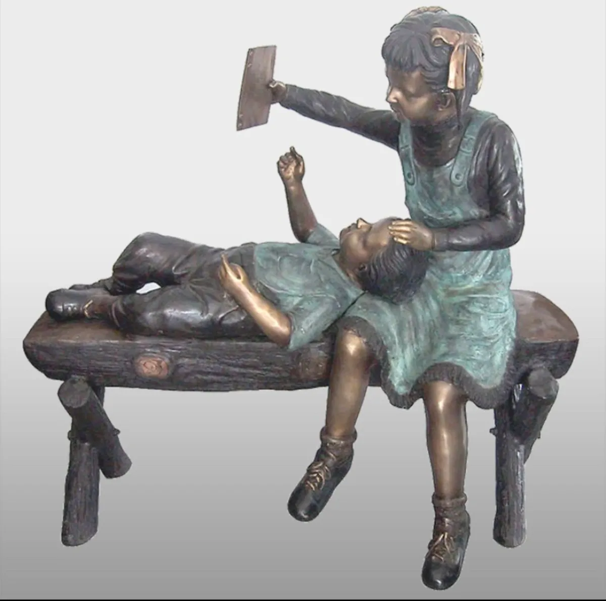 Bronze boy and girl on log bench - Image 1