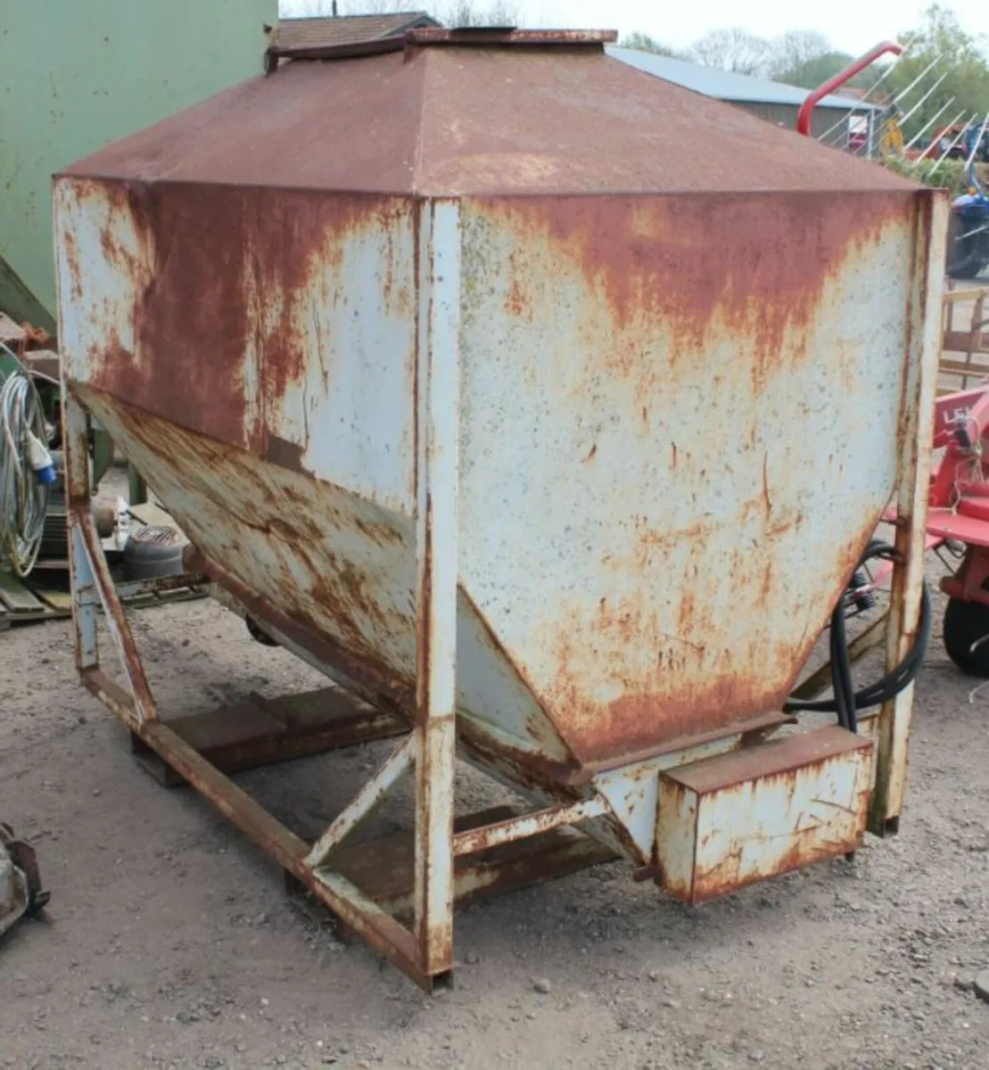 Feed hopper to fit pallet tines with hydraulic bot