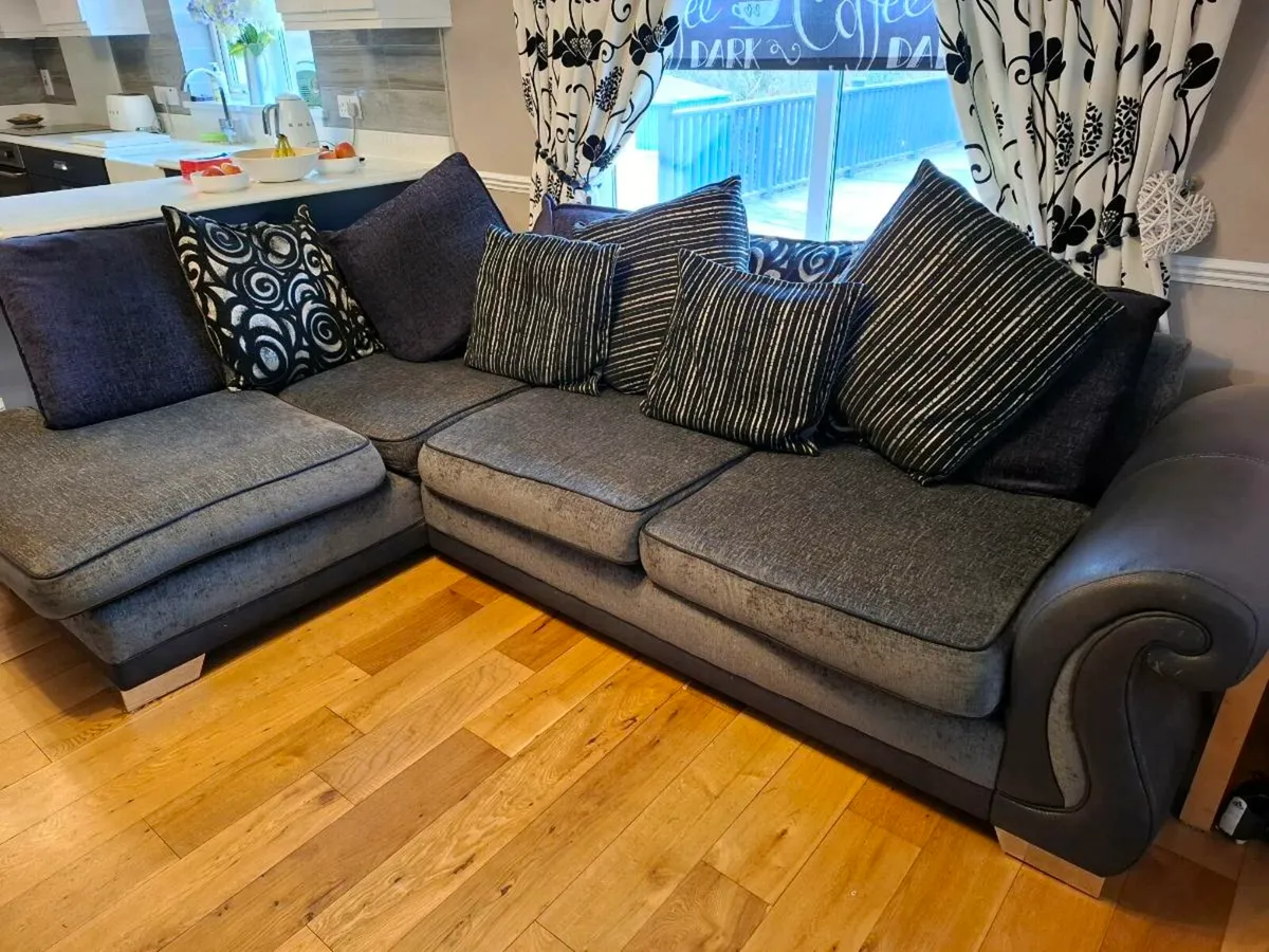 Large corner sofa in charcoal grey and black. - Image 1