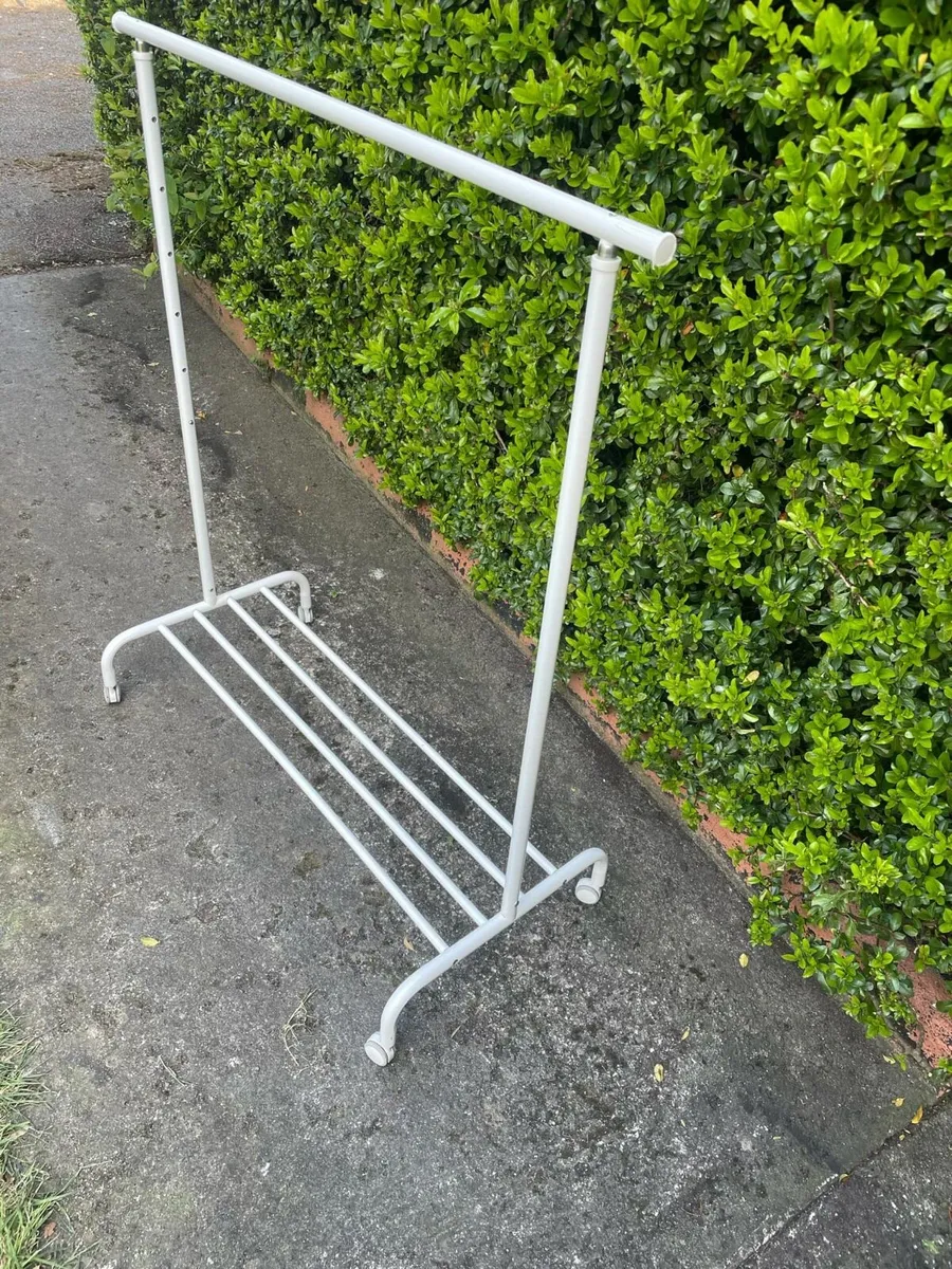 Clothes hanging on wheels rails - Image 1