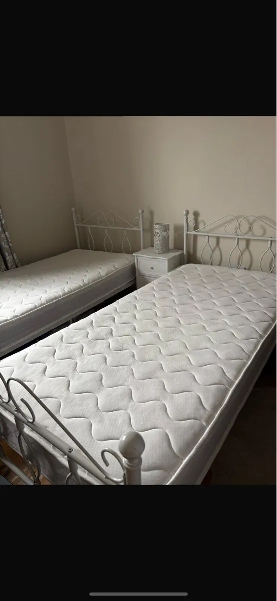 2 single bed frames and 2 single mattresses. - Image 1