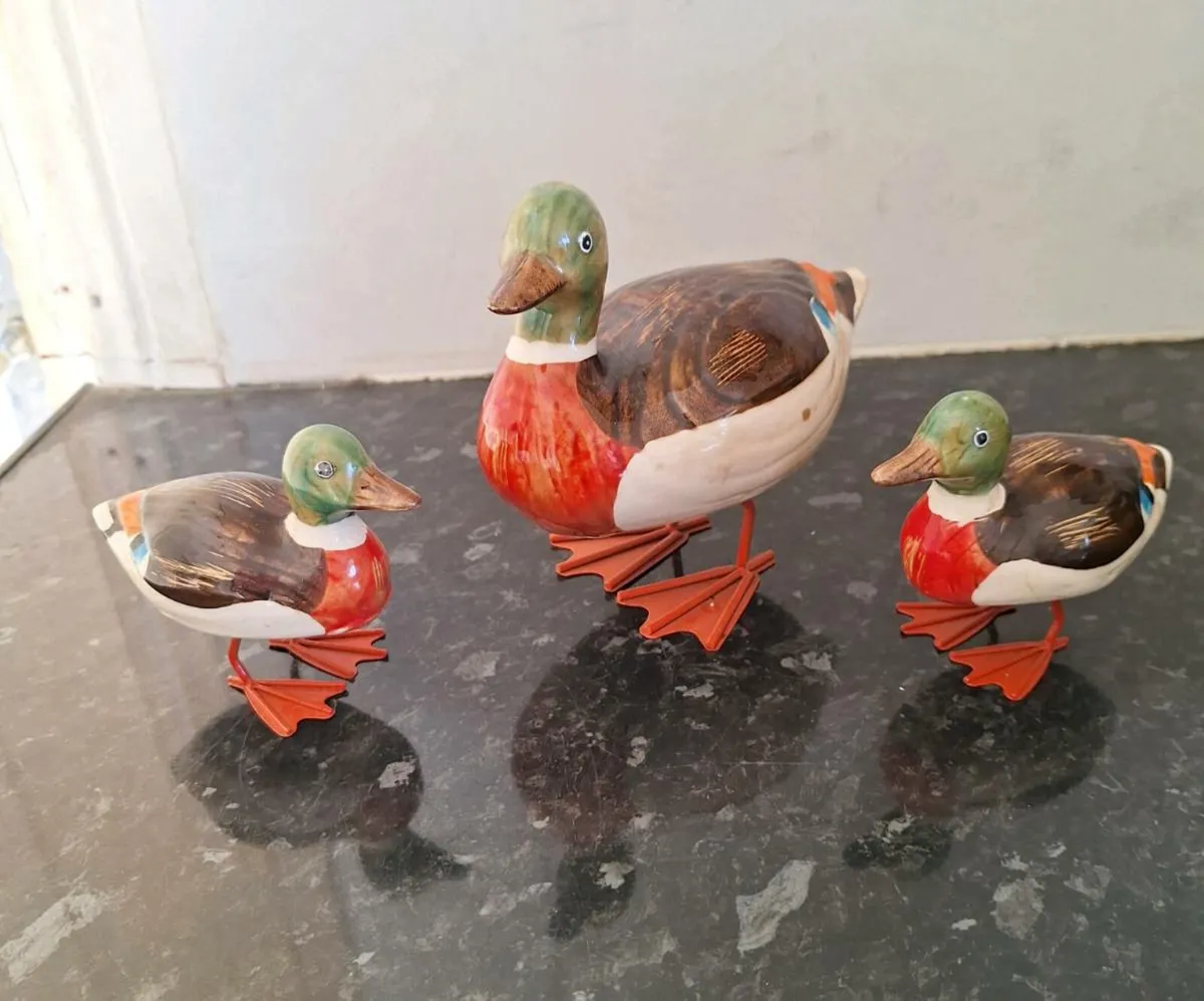 Three small ceramic ducks with metal spring legs