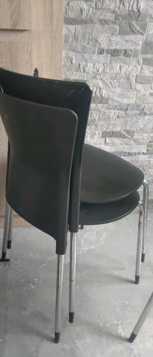 Black plastic chairs with silver legs . - Image 2