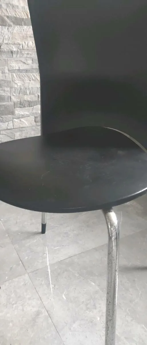 Black plastic chairs with silver legs . - Image 3
