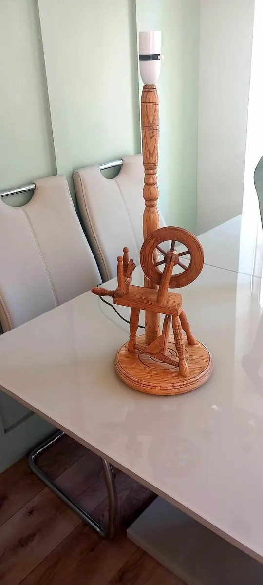 A vintage wooden spinning wheel lamp