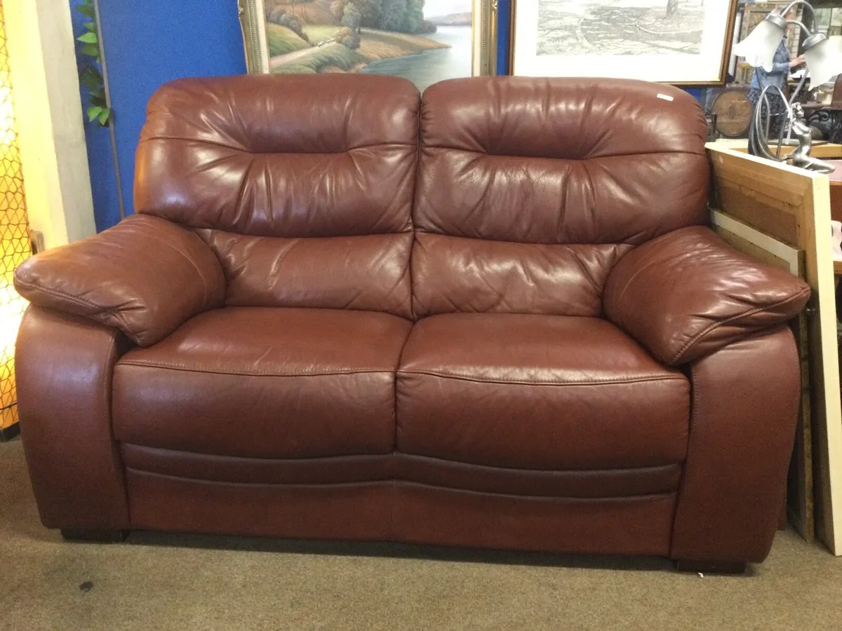 A large rust two seater leather sofa