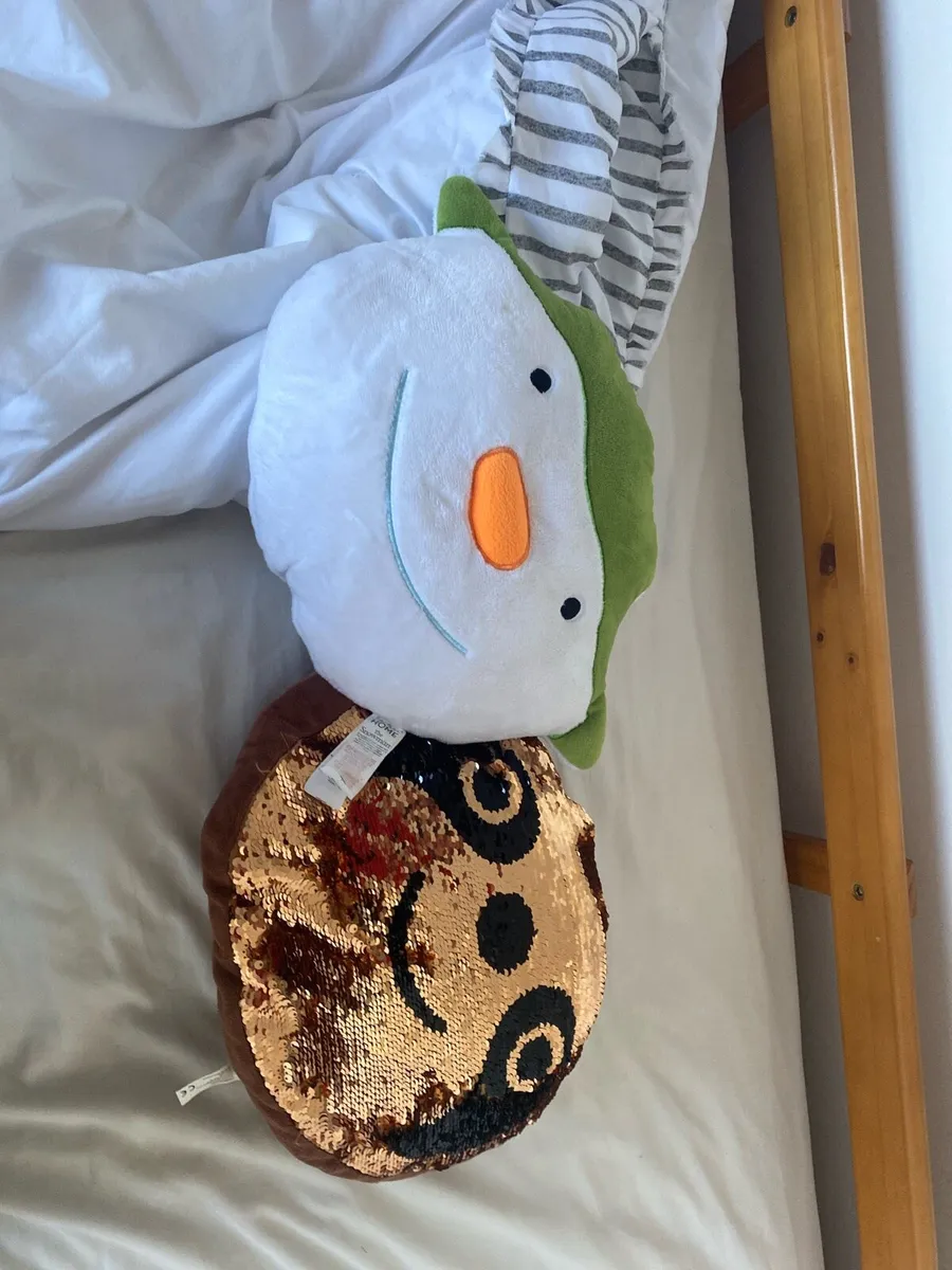 A snowman pillow and a sloth pillow