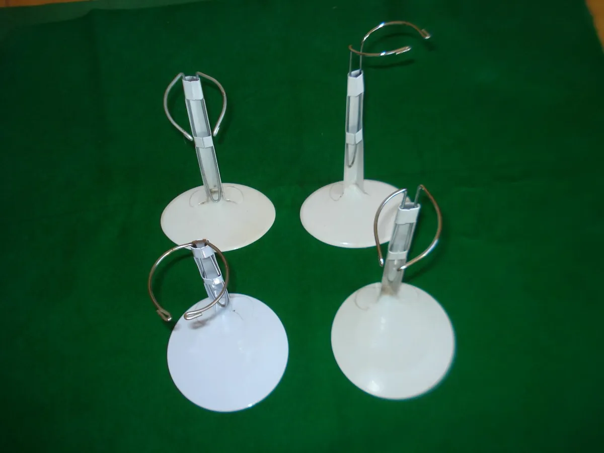 4 METAL ADJUSTABLE DOLL STANDS. - Image 1