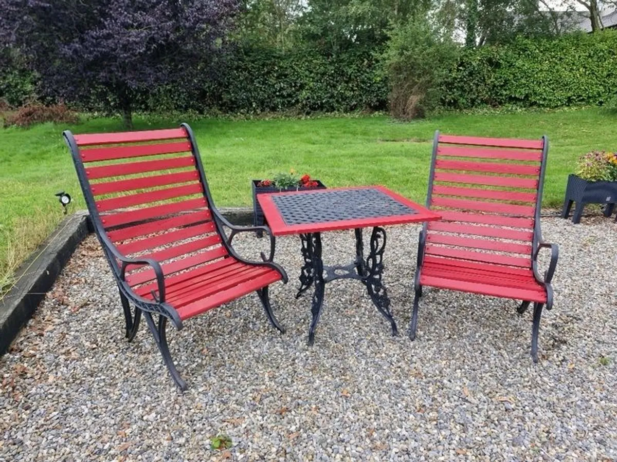 Heavy cast iron table and two high back chairs - Image 1
