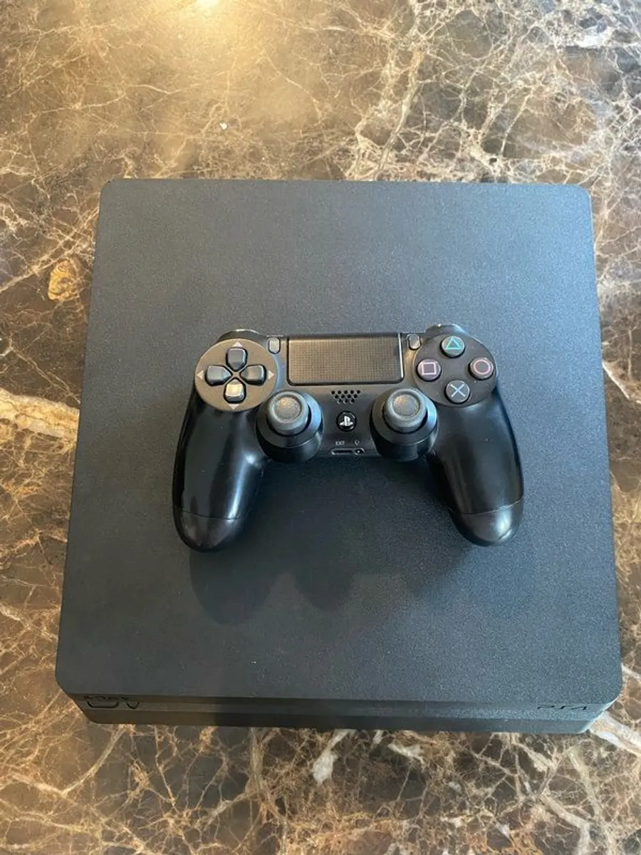 PS4 with DualShock4 controller and headset. - Image 1