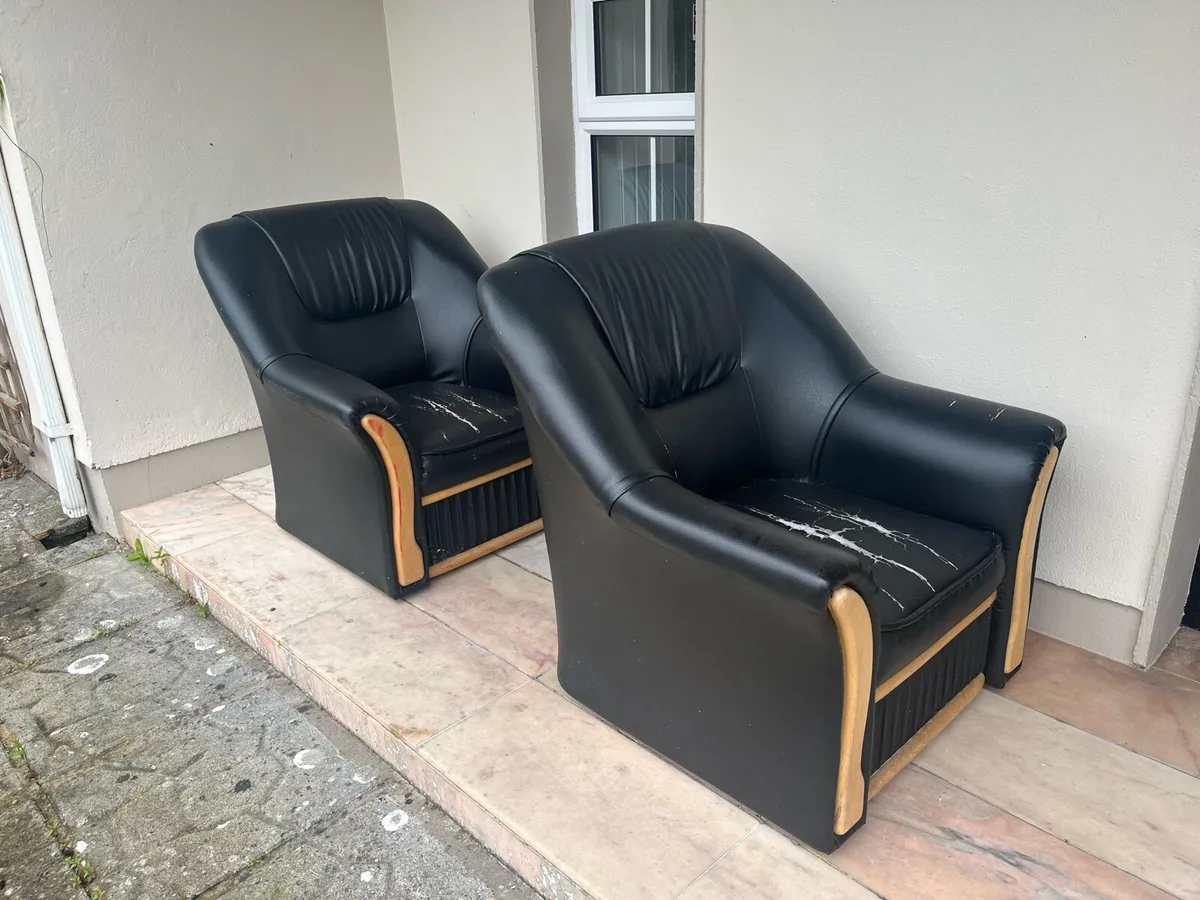 Two black leatherette armchairs