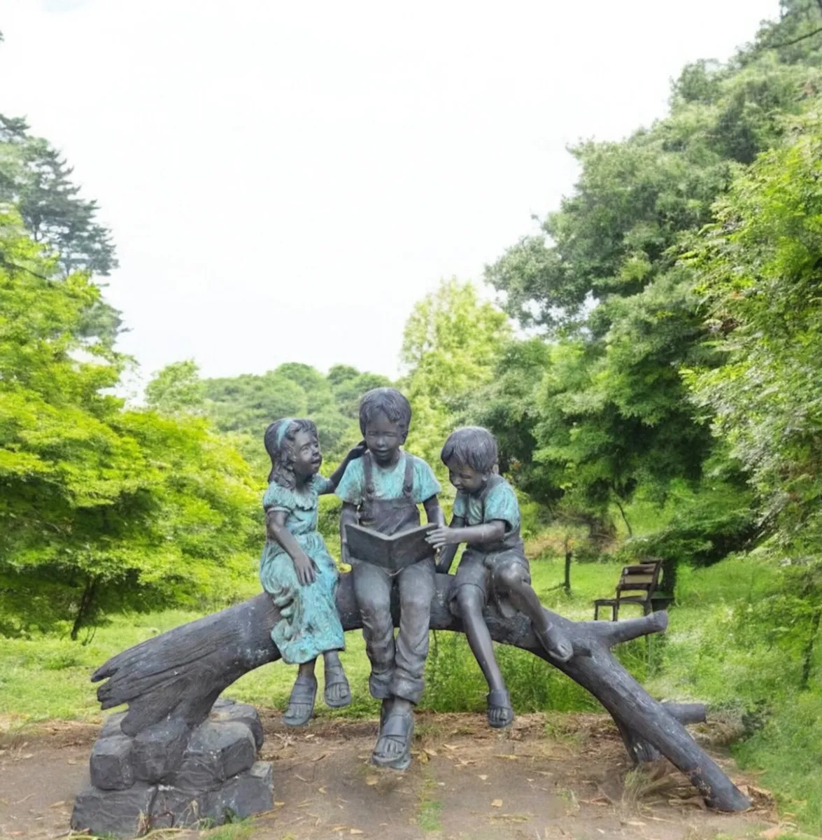 Bronze kids reading on log - Image 2