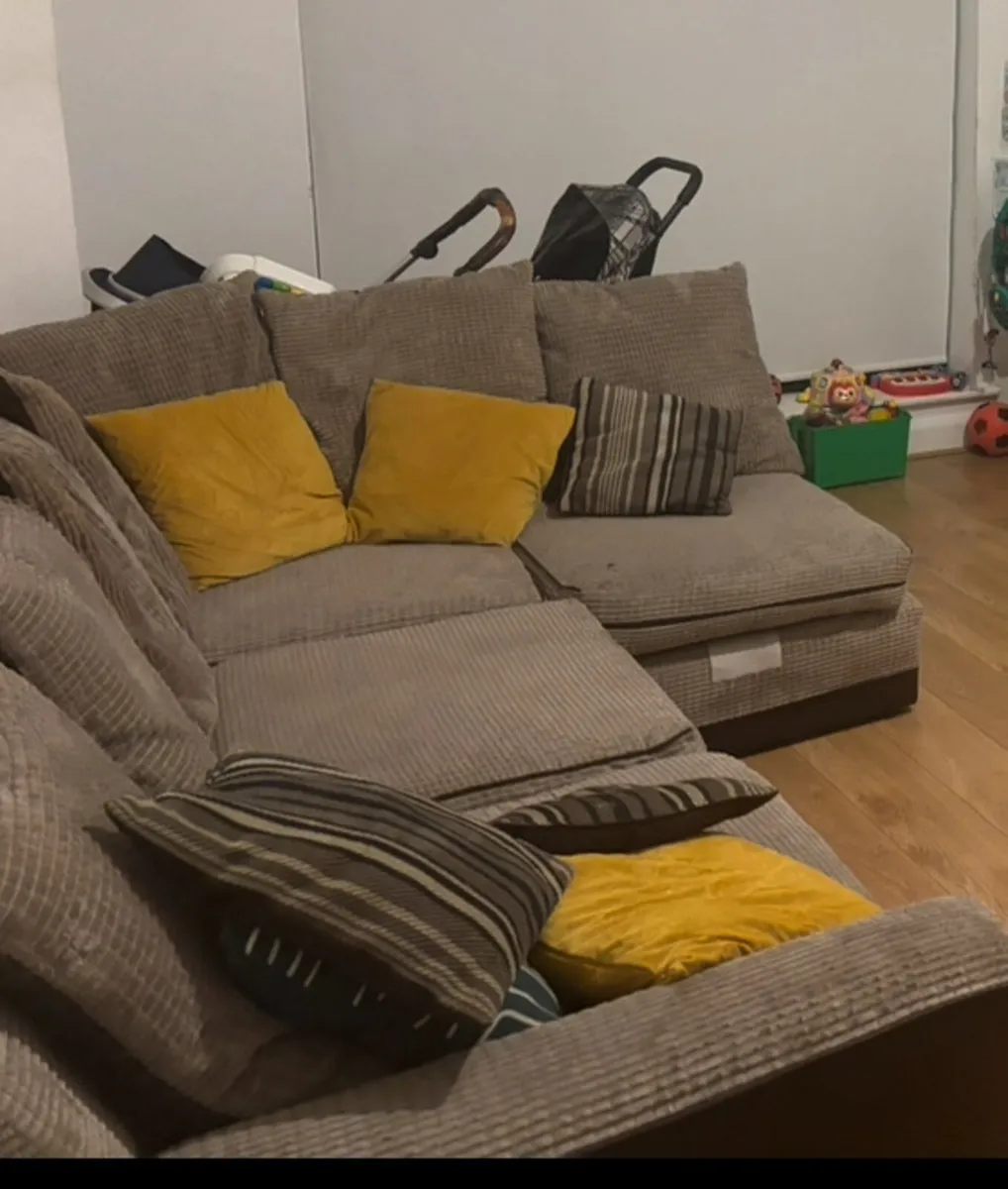 corduroy L-shaped corner sofa with throw pillows. - Image 1