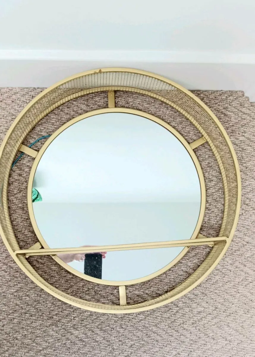 Round gold metal framed wall mirror with shelf