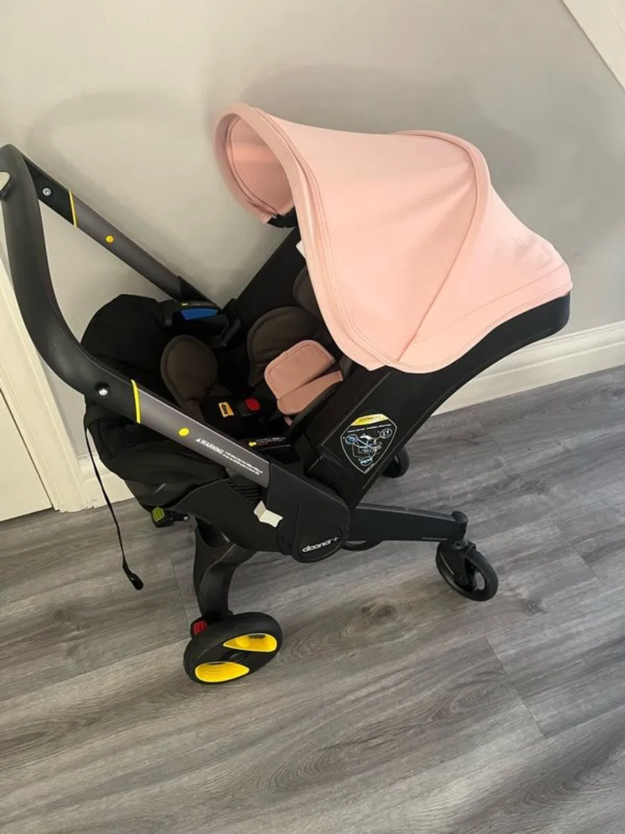 Pink Doona+ pram with base and rain cover - Image 1