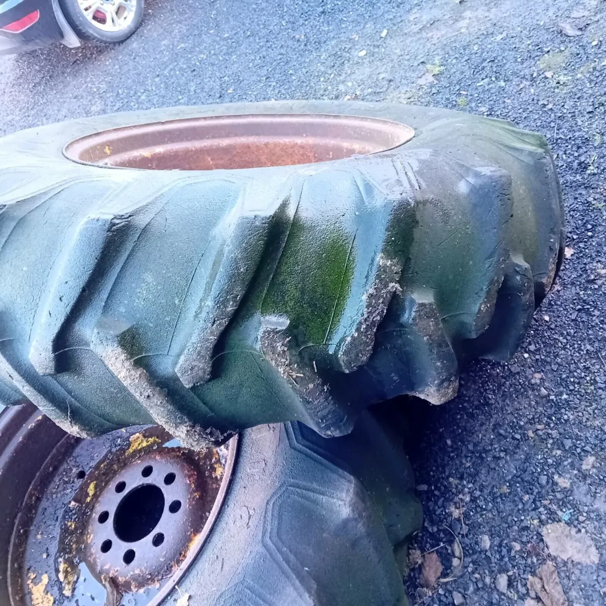 One  16.9x28  tire and rim and concrete weight - Image 1