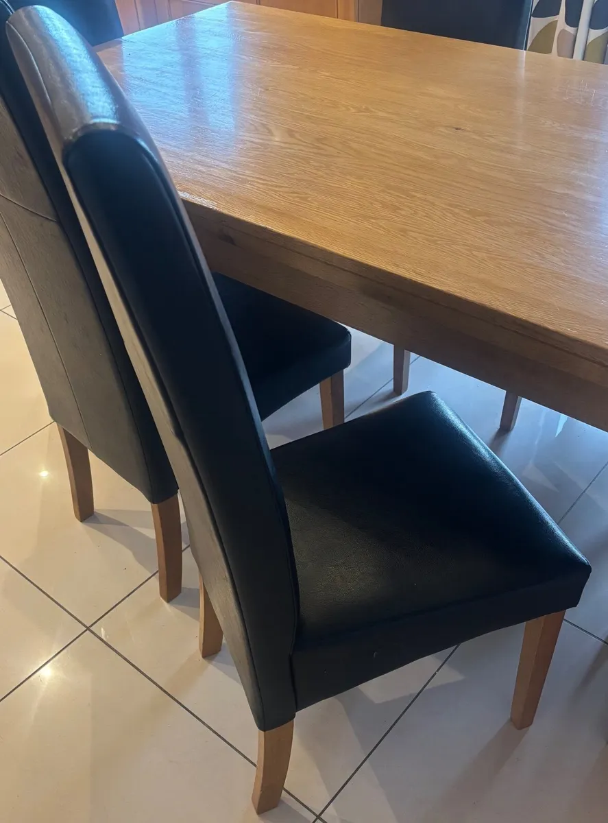 Oak dining table and black leatherette chairs - Image 1