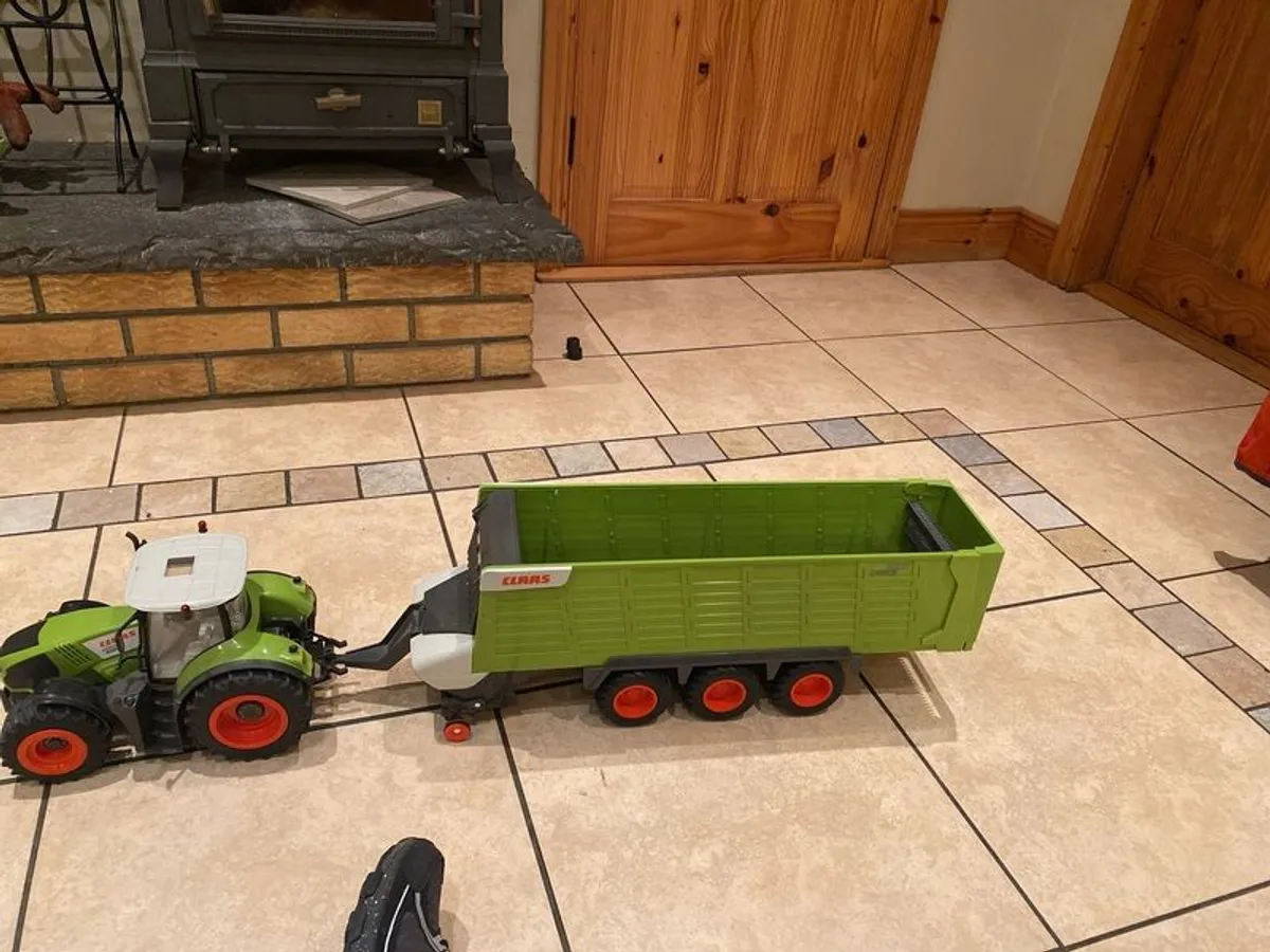 Claas remote control tractor with triaxle silage wagon - Image 1