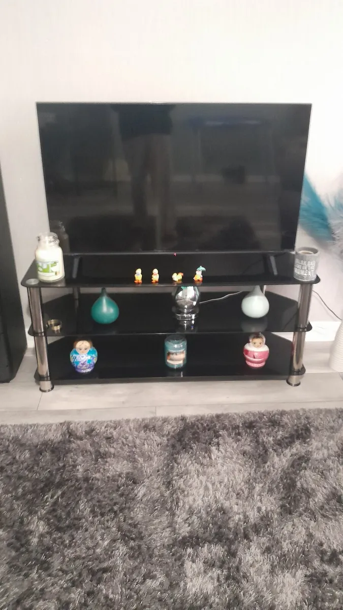 tv and black glass stand