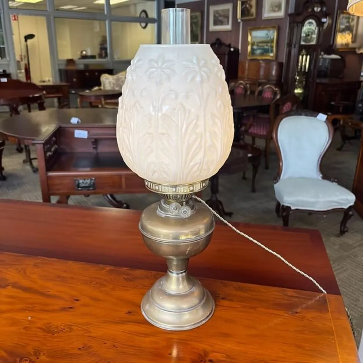 Brass base, embossed milk glass shade with a folia