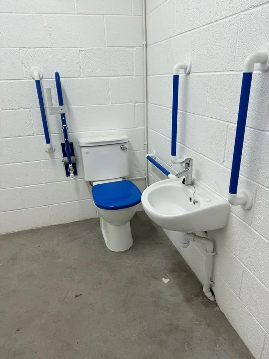 Toilet with handrails, two sinks, unused. - Image 1