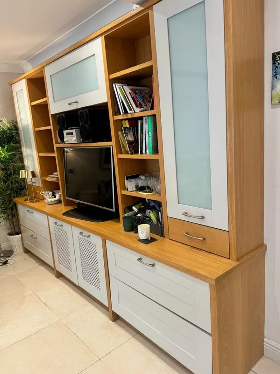 large wooden entertainment center or wall unit featuring a mix of open shelving, glass fronted cabinets, and lower drawers - Image 1