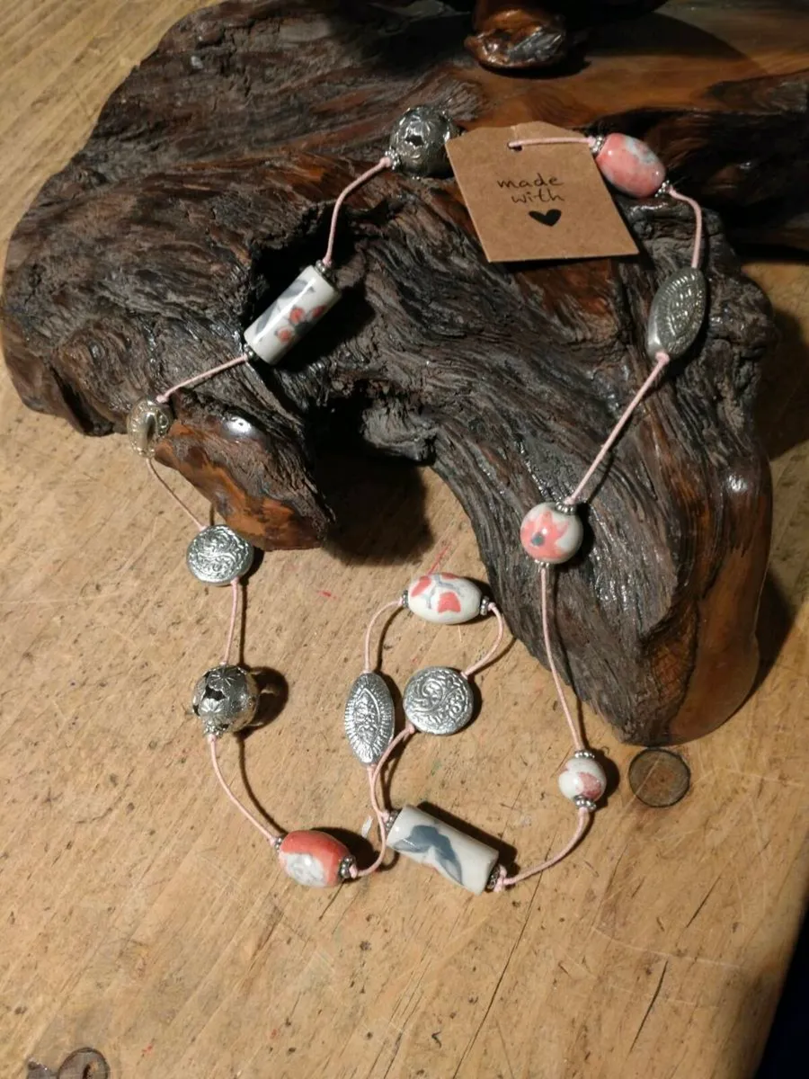 This handmade necklace features a combination of c - Image 1
