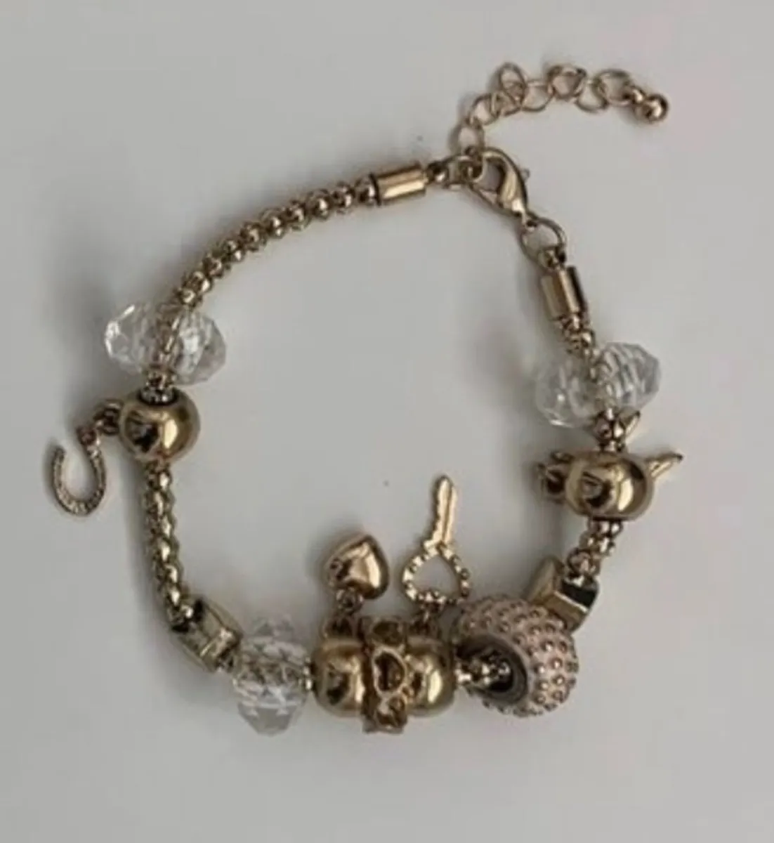 gold-plated charm bracelet featuring clear crystal