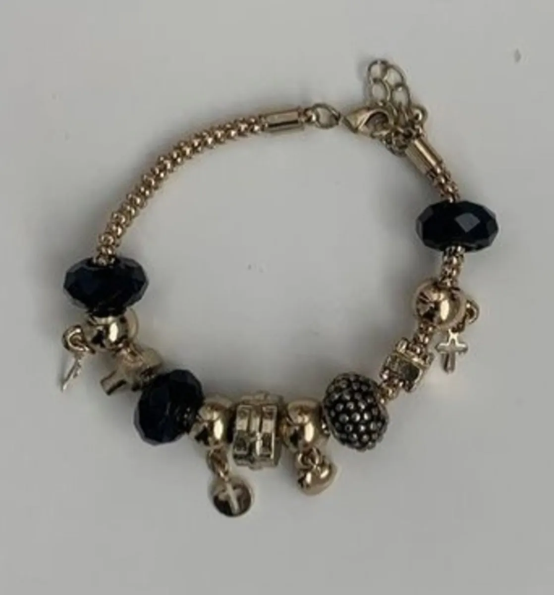 gold-tone charm bracelet featuring black faceted b