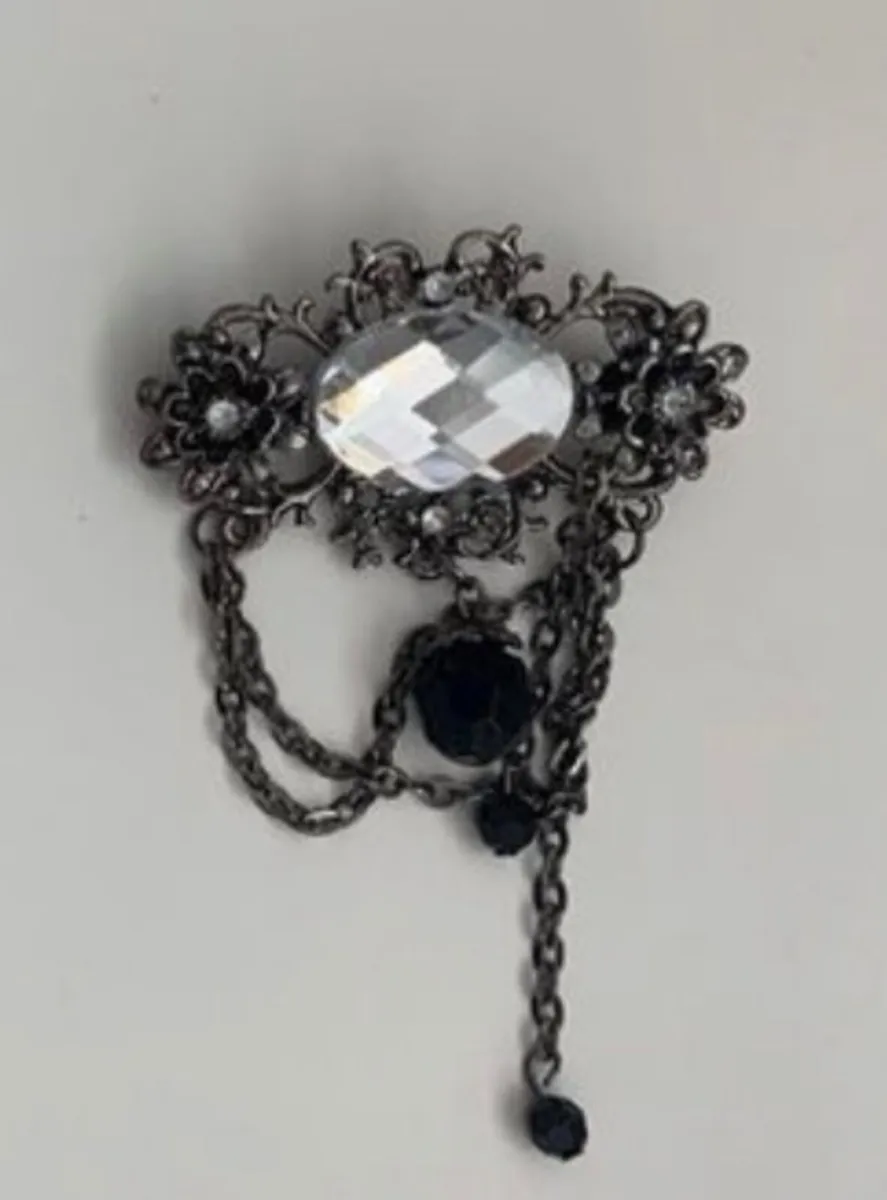 black crystal double chain brooch featuring a gunm