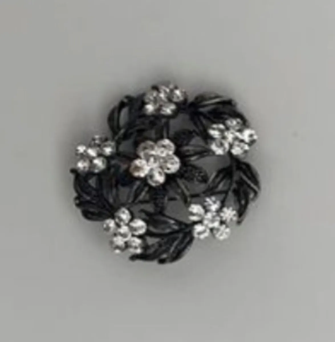 vintage-style floral brooch featuring clear rhines