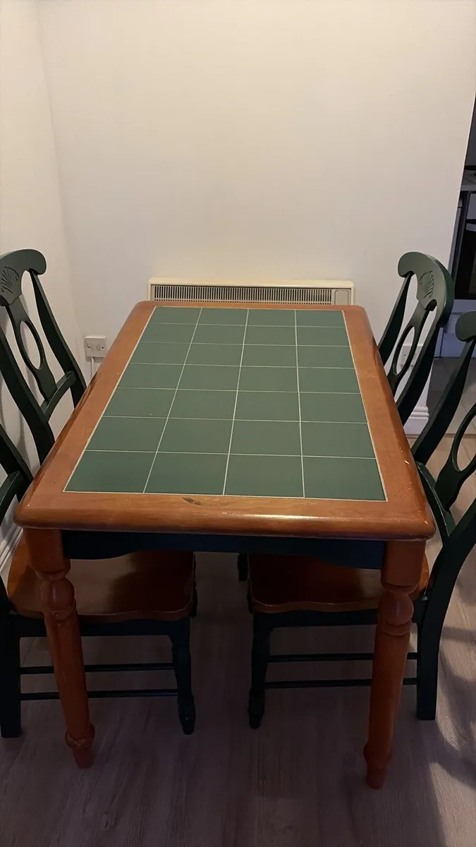 Solid wood table with green tile top and 4 chairs.