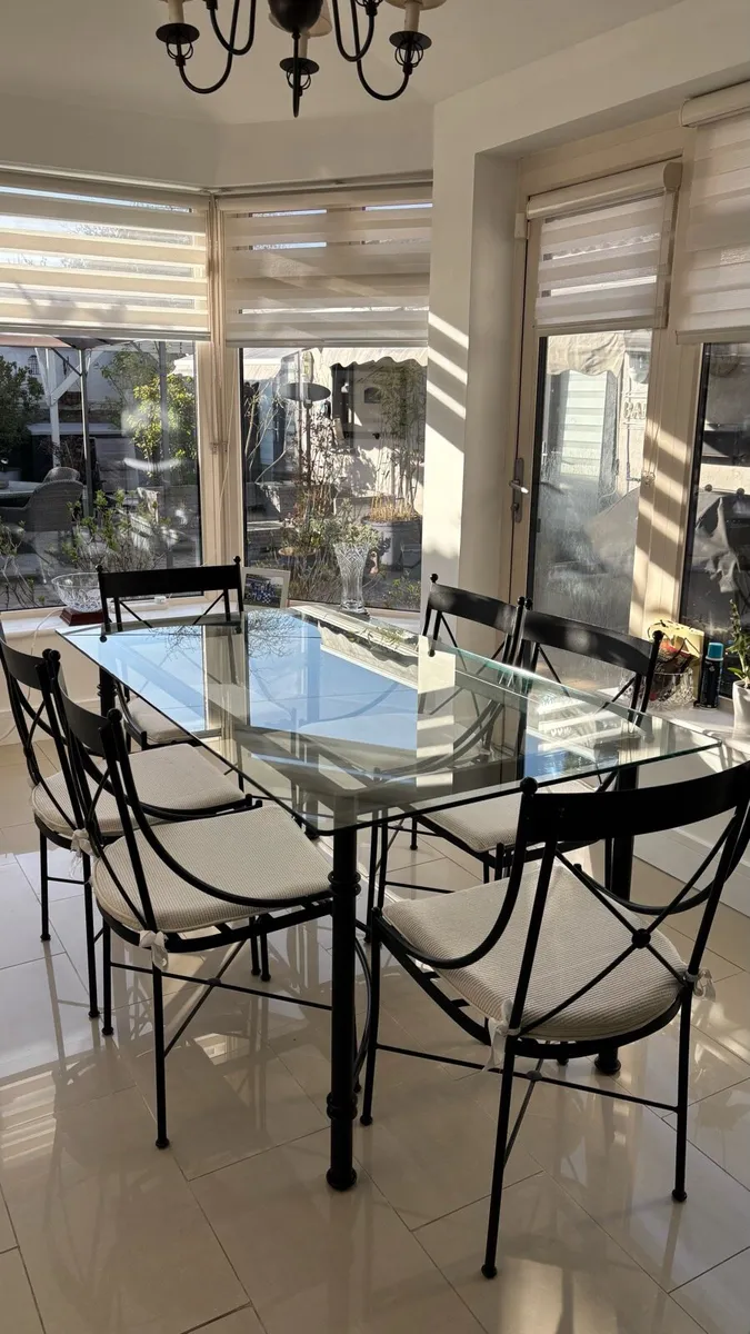 Glass and steel dining table with matching chairs - Image 1