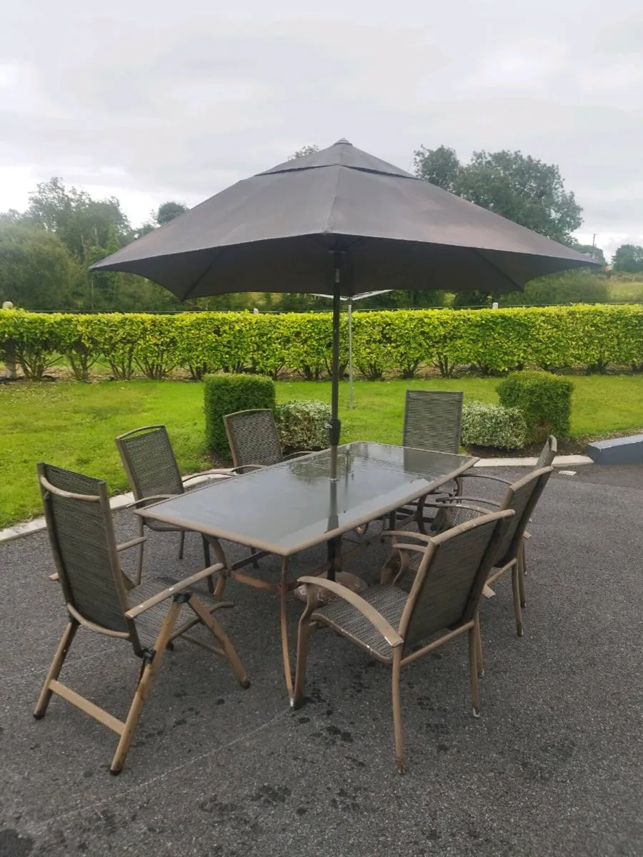 Outdoor table and chairs and umbrella. - Image 2