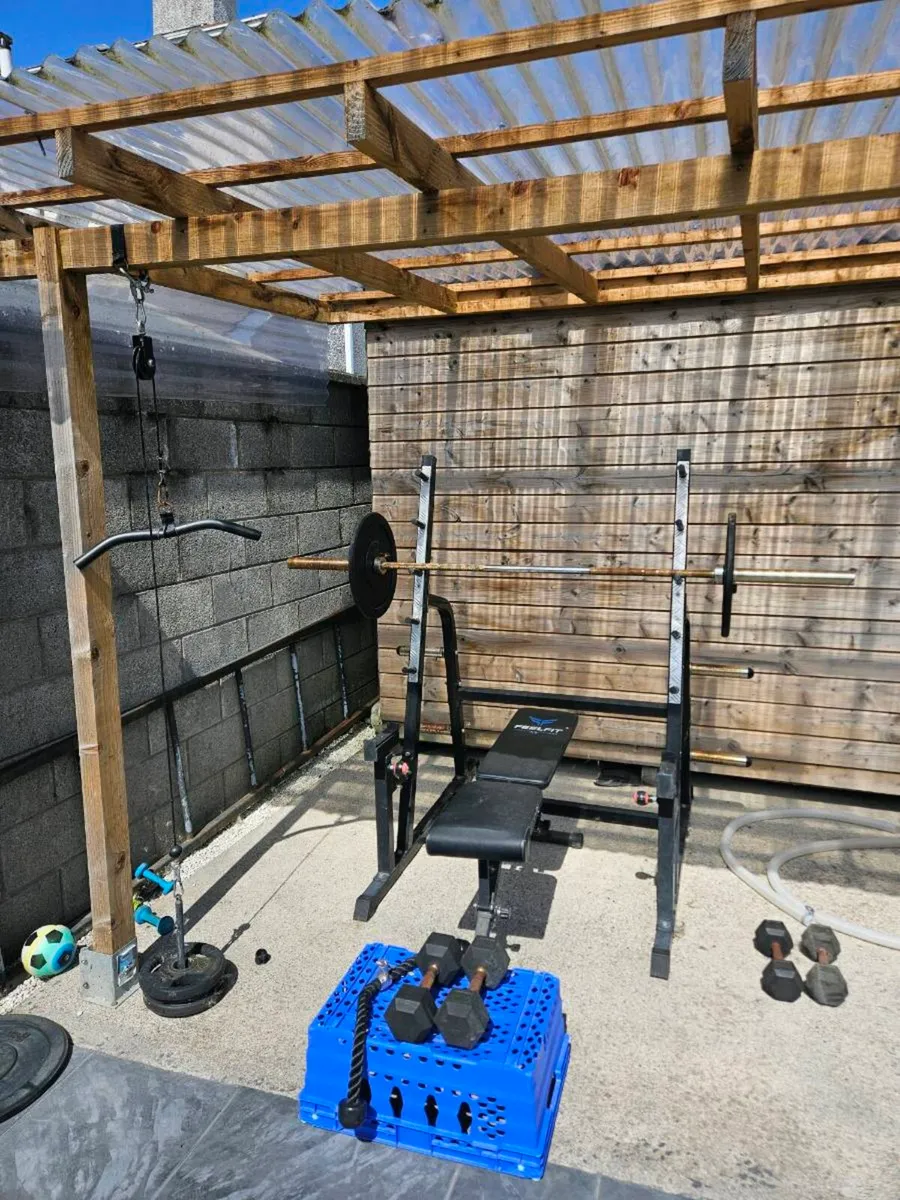 Squat rack + barbell + bumper plates + pull down + - Image 1