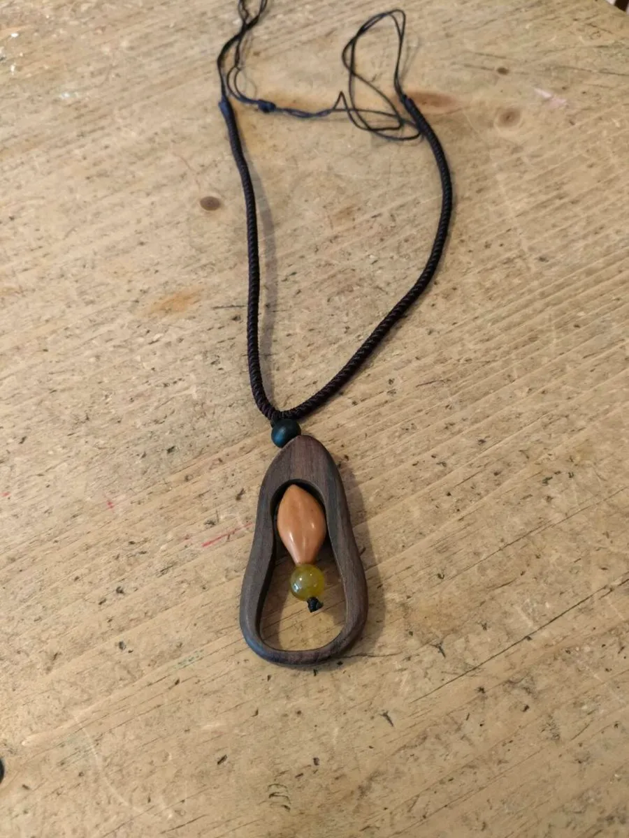 wooden pendant necklace featuring a dark brown woo - Image 1