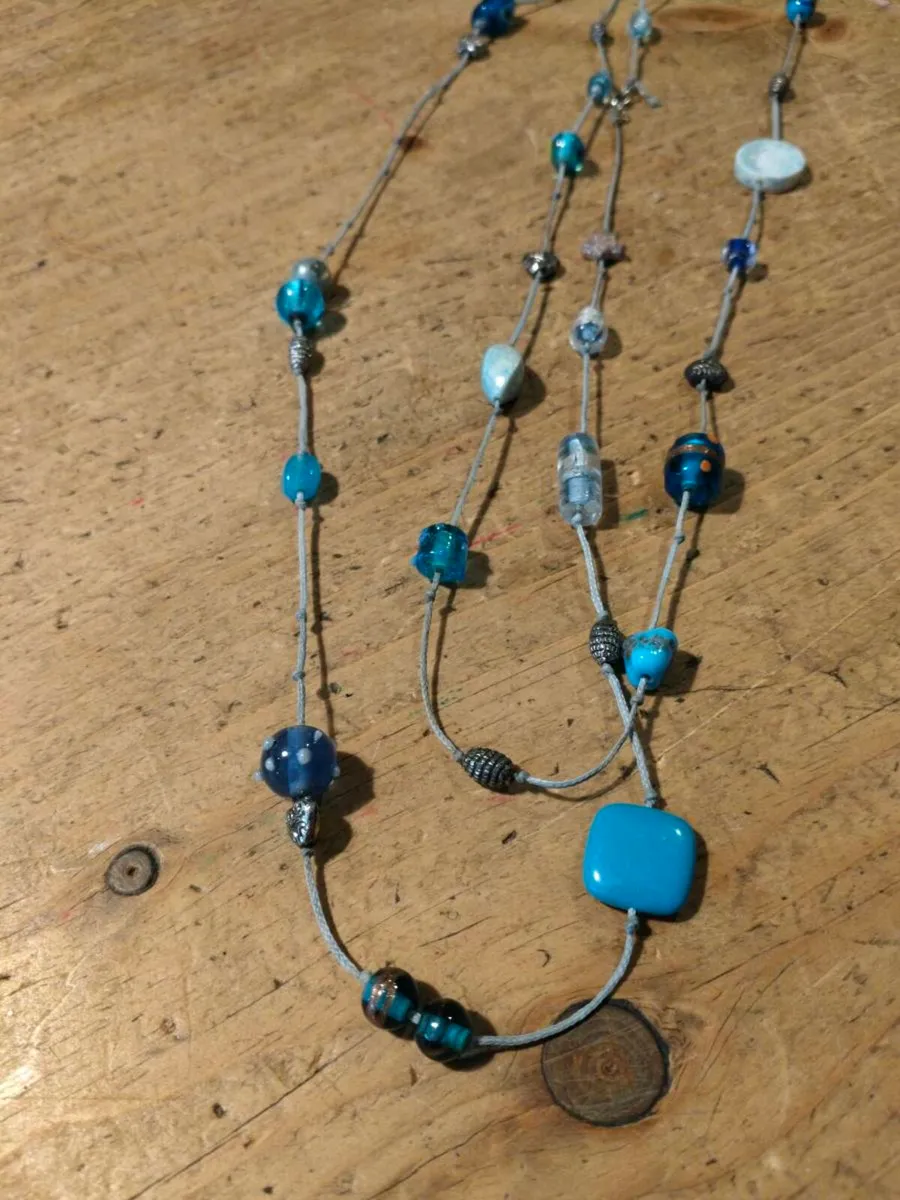 long necklace featuring a mix of blue-toned glass - Image 1