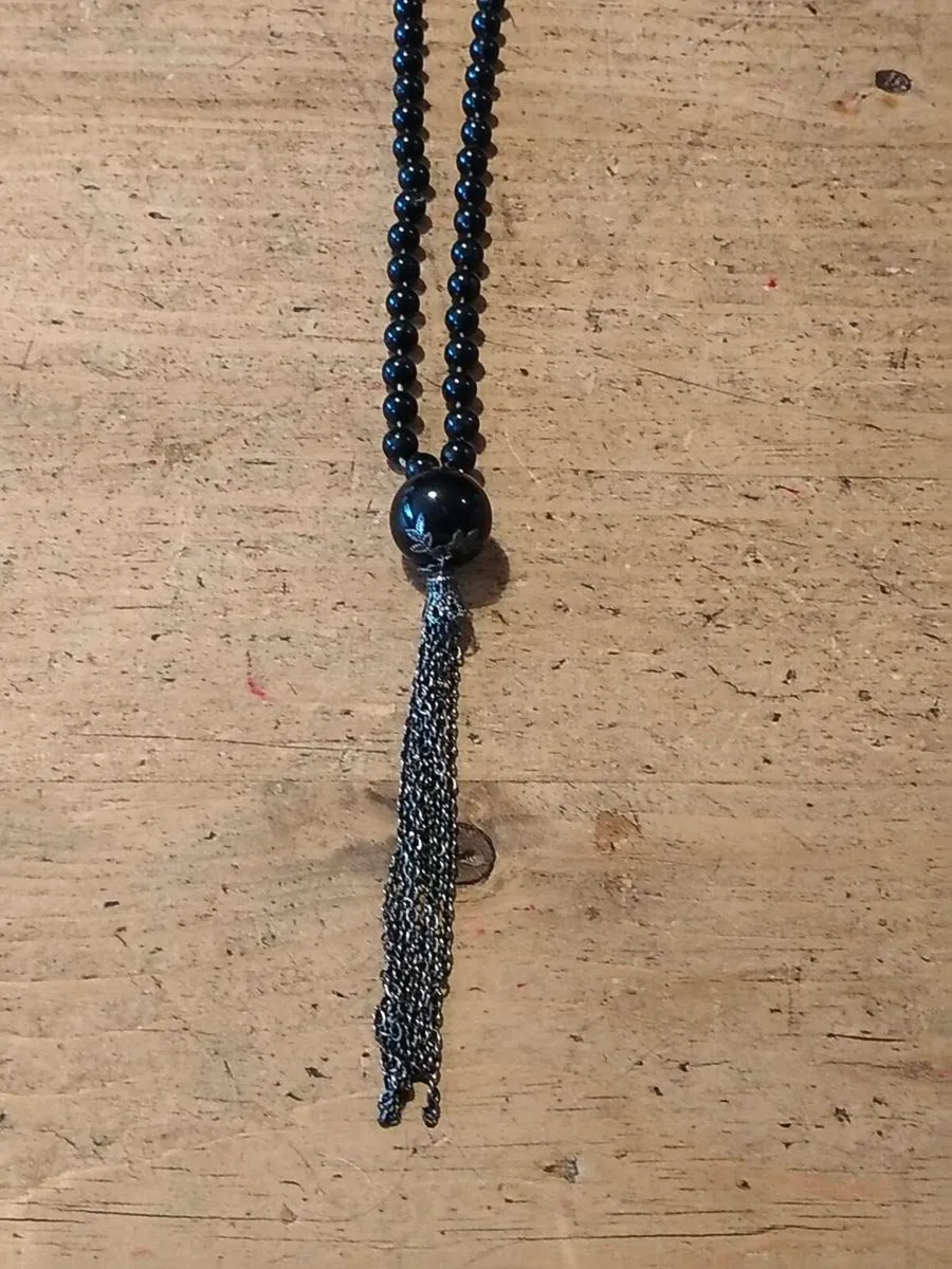 Black necklace features small black beads and a lo - Image 1