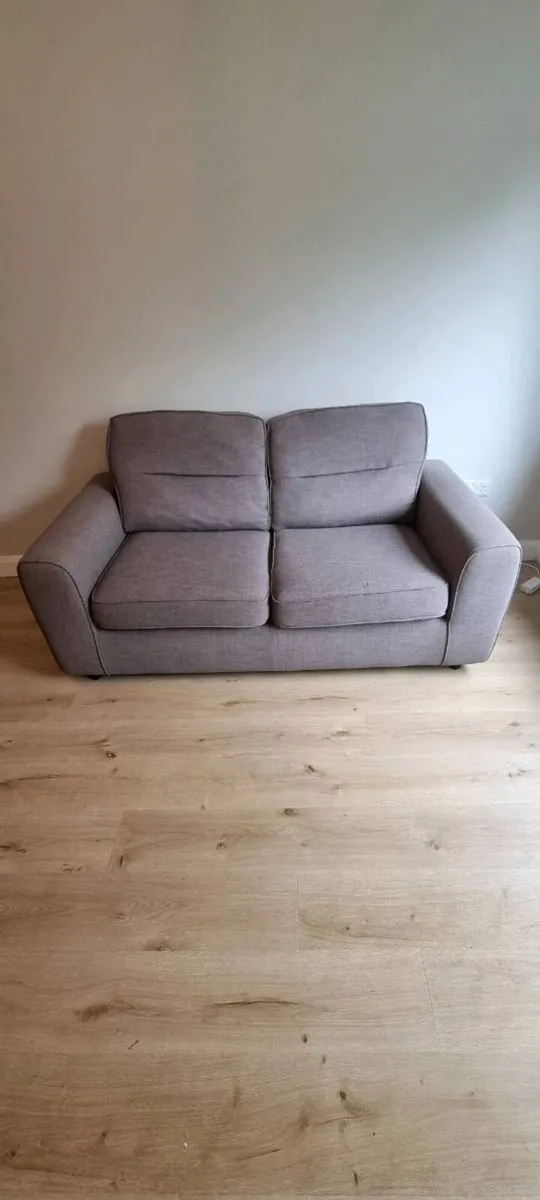 Grey two-seater sofa bed - Image 1