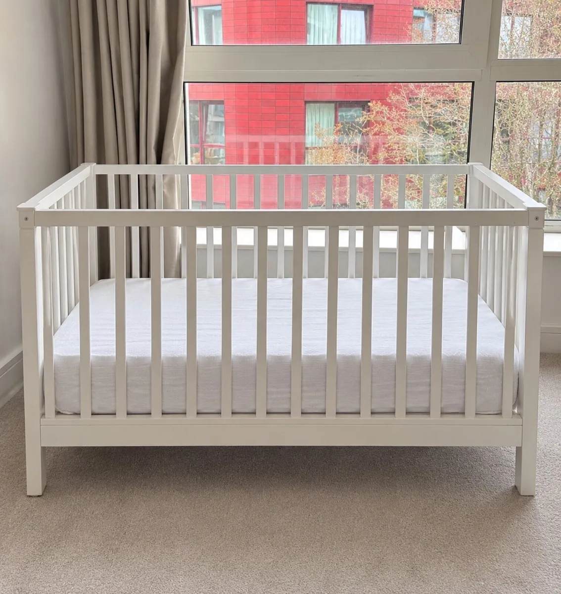 White baby cot with mattress
